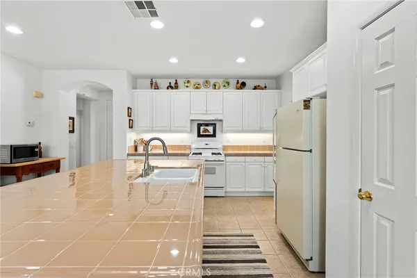 a view of kitchen with refrigerator stove and wooden cabinets