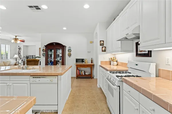 a kitchen with stainless steel appliances a sink a stove top oven a counter space and cabinets