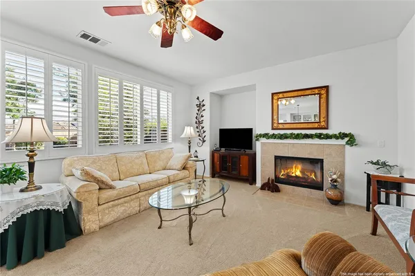 a living room with furniture a fireplace and a large window