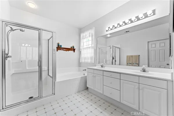 a spacious bathroom with a double vanity sink mirror and shower