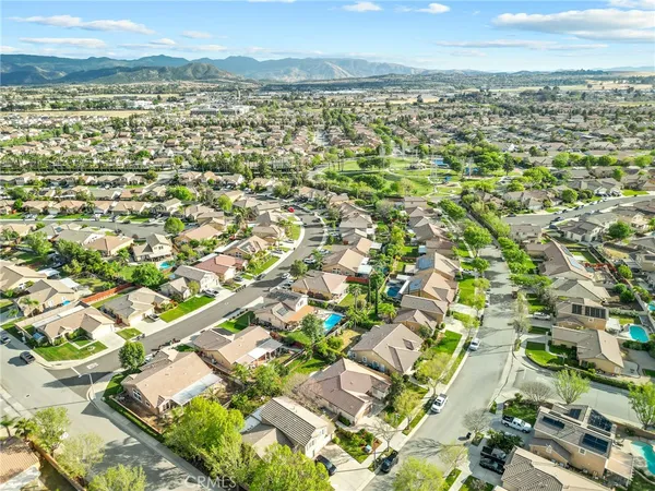 an aerial view of residential houses with outdoor space and trees