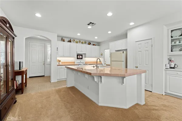 a large kitchen with kitchen island a sink stainless steel appliances and cabinets