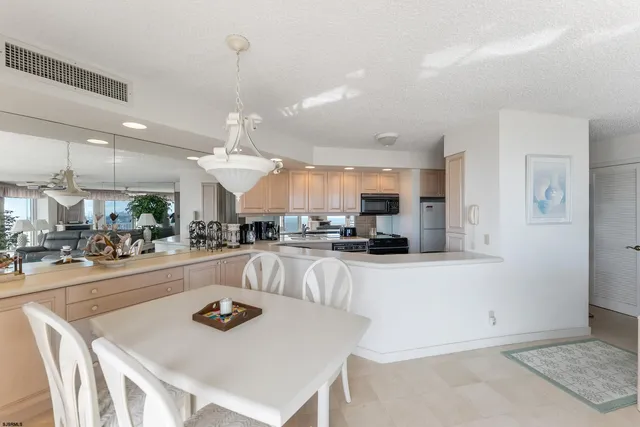 a kitchen with stainless steel appliances kitchen island granite countertop a sink and a refrigerator