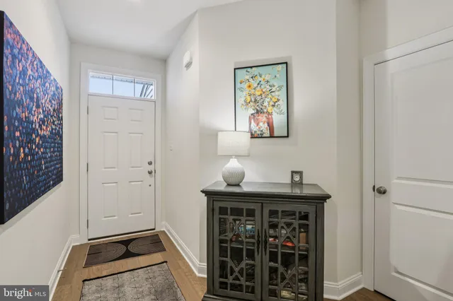 a kitchen with stainless steel appliances a stove a sink a refrigerator white cabinets and wooden floor