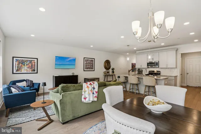a living room with furniture kitchen view and a table