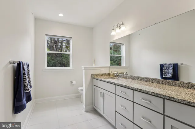 a bathroom with a granite countertop shower sink and mirror