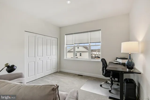 a view of a workspace with furniture and a window