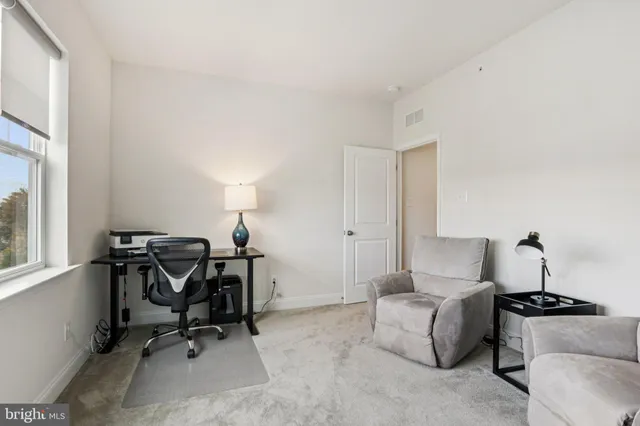 a bedroom with a bed and a lamp on dresser