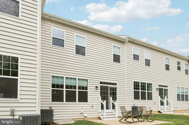 a view of house with a backyard and chairs
