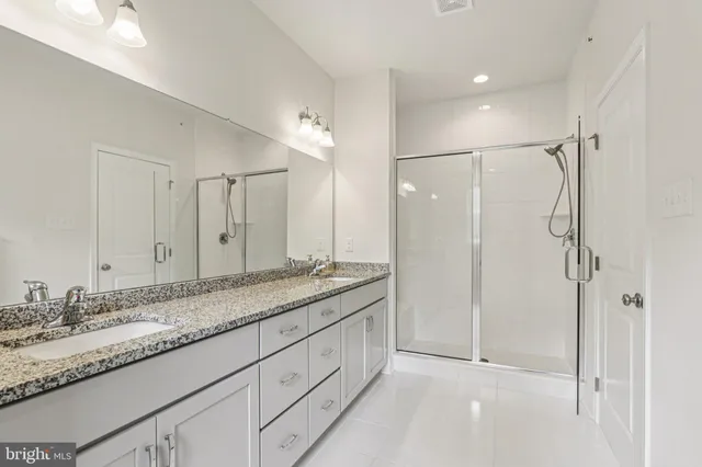 a bathroom with a granite countertop sink mirror and double