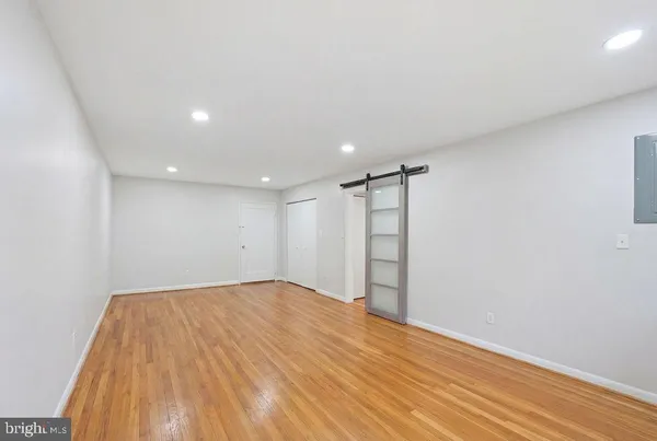 a view of empty room with wooden floor