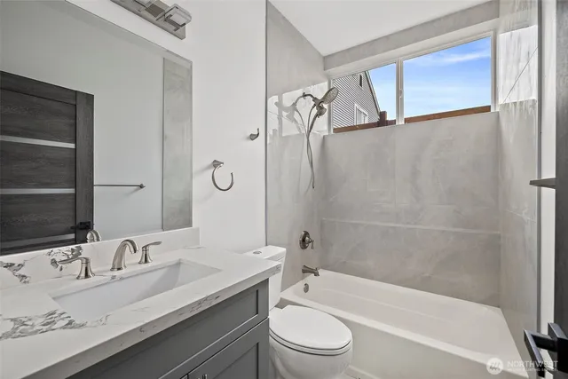 a bathroom with a granite countertop sink toilet and shower