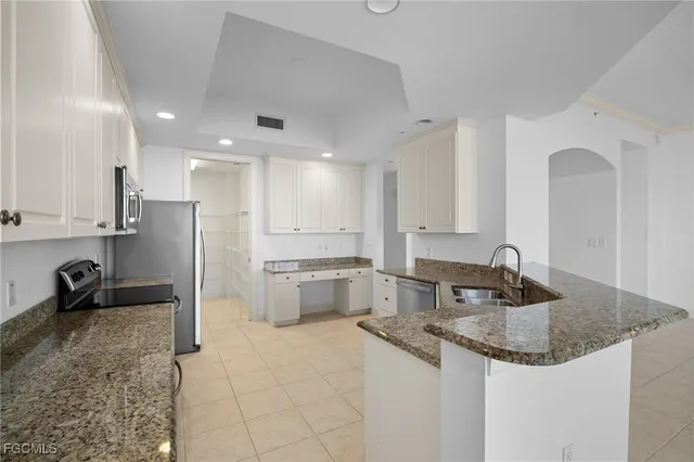 a kitchen with granite countertop cabinets stainless steel appliances and a counter space