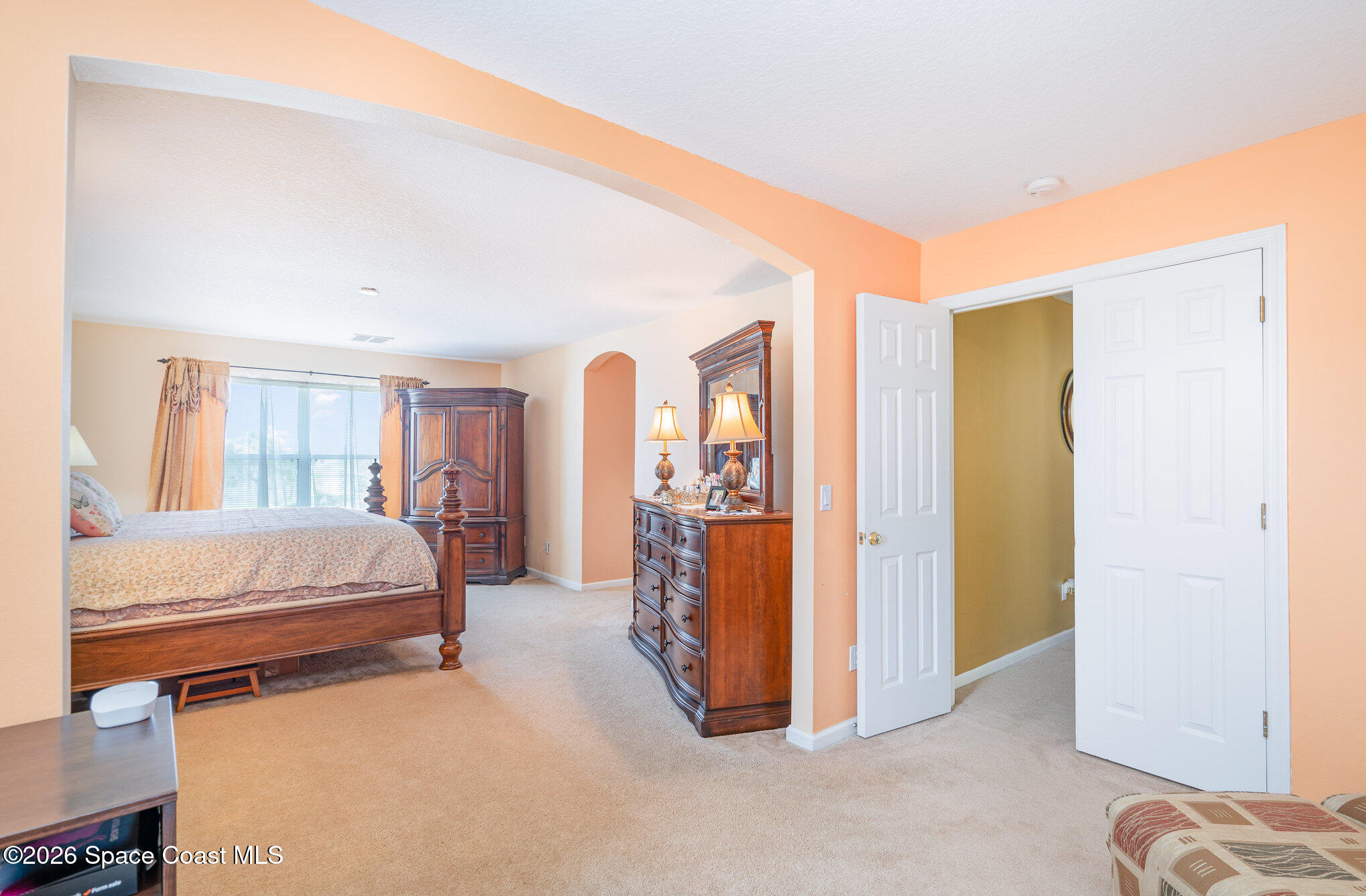 154 Wading Bird Circle Southwest Palm Bay, FL 32908 - Photo 17 of 45 a spacious bedroom with a bed and a walk in closet