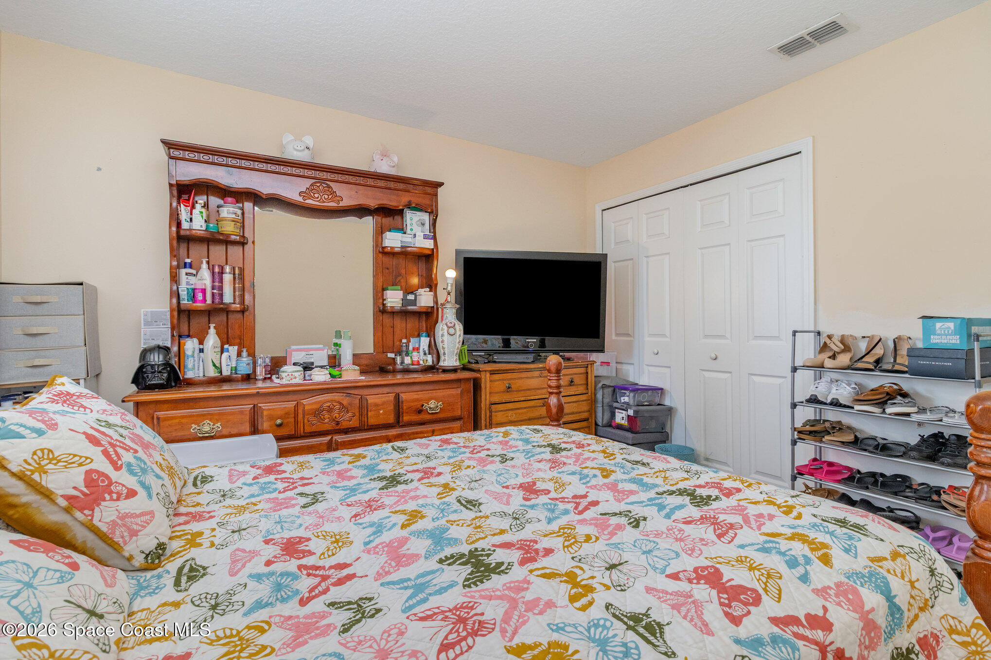 154 Wading Bird Circle Southwest Palm Bay, FL 32908 - Photo 25 of 45 a bedroom with bed and a flat tv screen on dresser