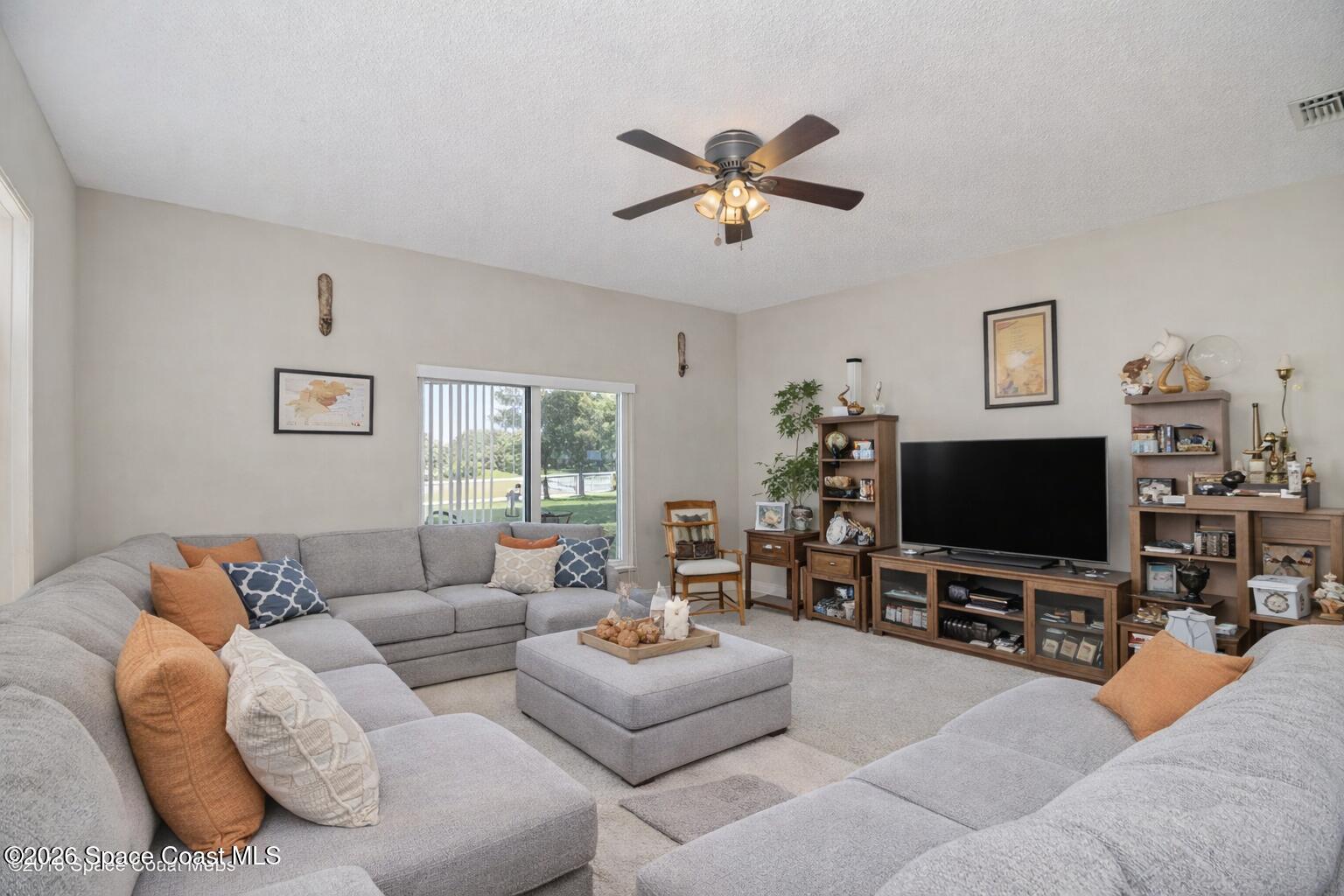 154 Wading Bird Circle Southwest Palm Bay, FL 32908 - Photo 3 of 45 a living room with furniture and a flat screen tv