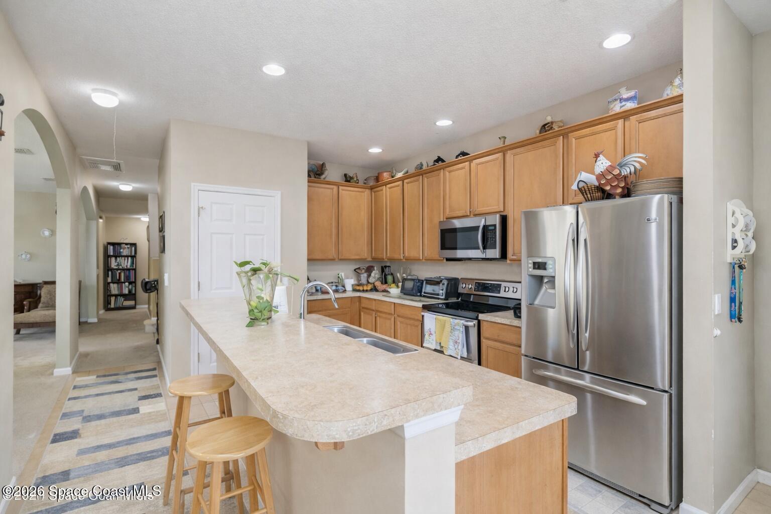154 Wading Bird Circle Southwest Palm Bay, FL 32908 - Photo 4 of 45 a kitchen with stainless steel appliances granite countertop a refrigerator and a stove top oven with wooden floor