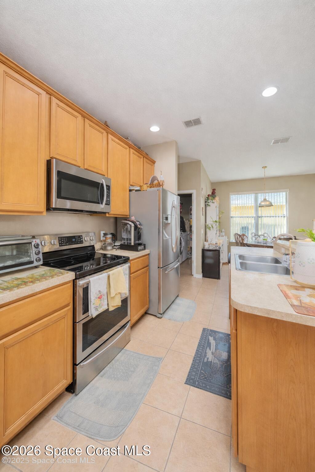 154 Wading Bird Circle Southwest Palm Bay, FL 32908 - Photo 6 of 45 a kitchen with stainless steel appliances granite countertop a stove a sink and a refrigerator