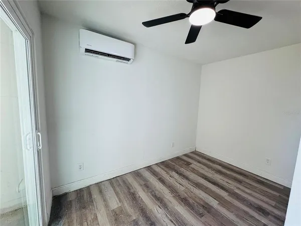 an empty room with a window and a ceiling fan