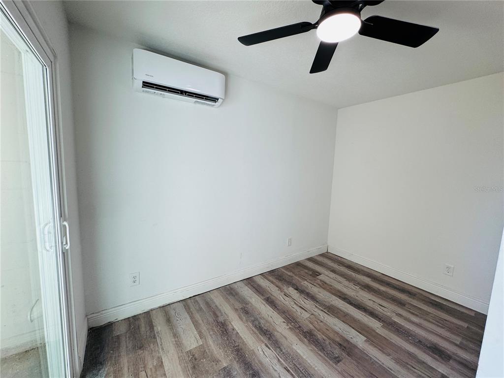 209 East Main Street Dundee, FL 33838 - Photo 11 of 13 an empty room with a window and a ceiling fan