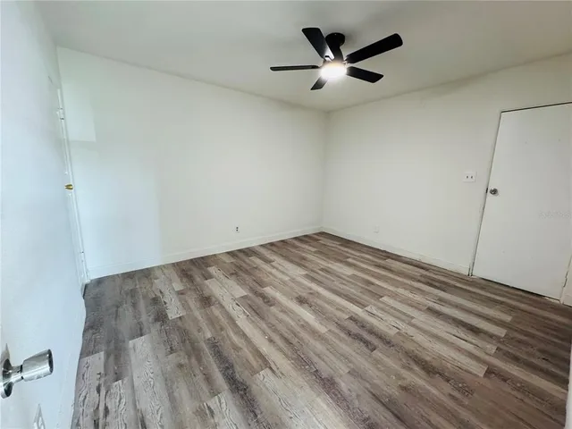 an empty room with ceiling fan and window