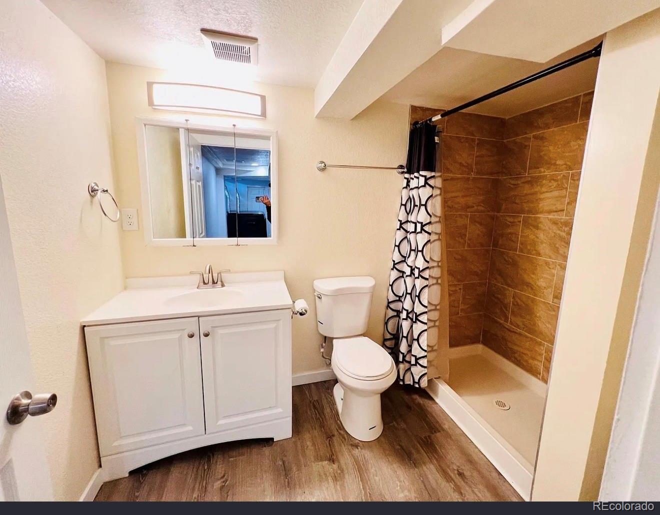 3146 Milwaukee Street Denver, CO 80205 - Photo 11 of 14 a bathroom with a sink toilet a mirror and shower