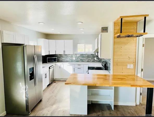 a kitchen with stainless steel appliances granite countertop a refrigerator a stove and a sink