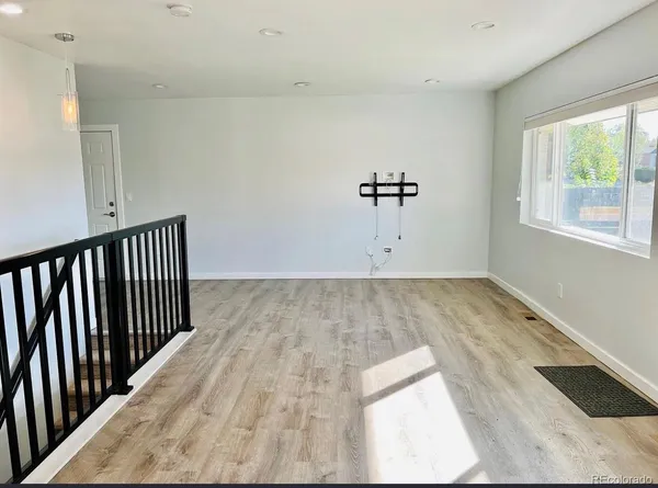 a view of a room with wooden floor and window