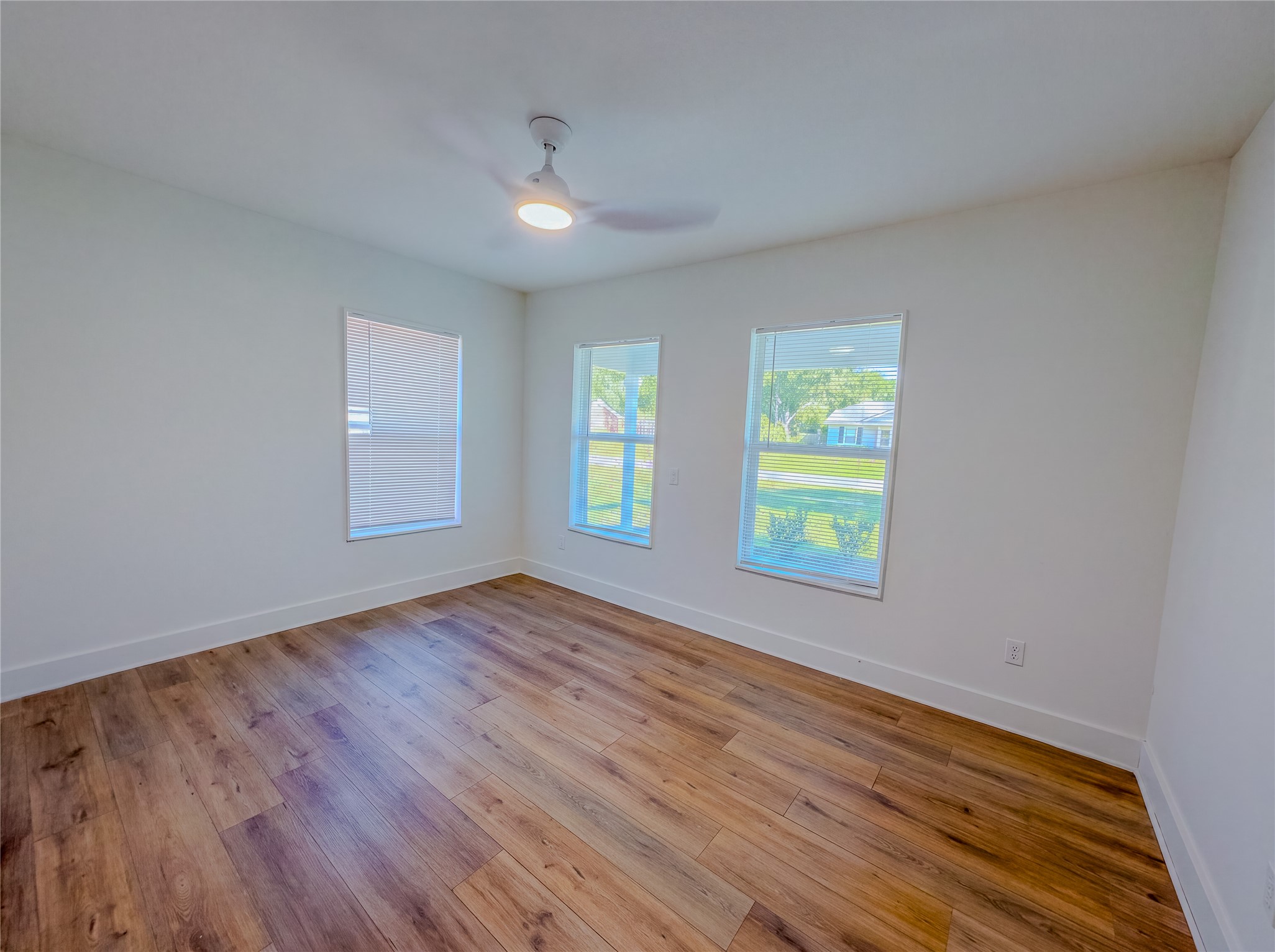 1120 Mark Street Austin, TX 78721 - Photo 11 of 22 Warm wood flooring and abundant natural light define this versatile bedroom space.