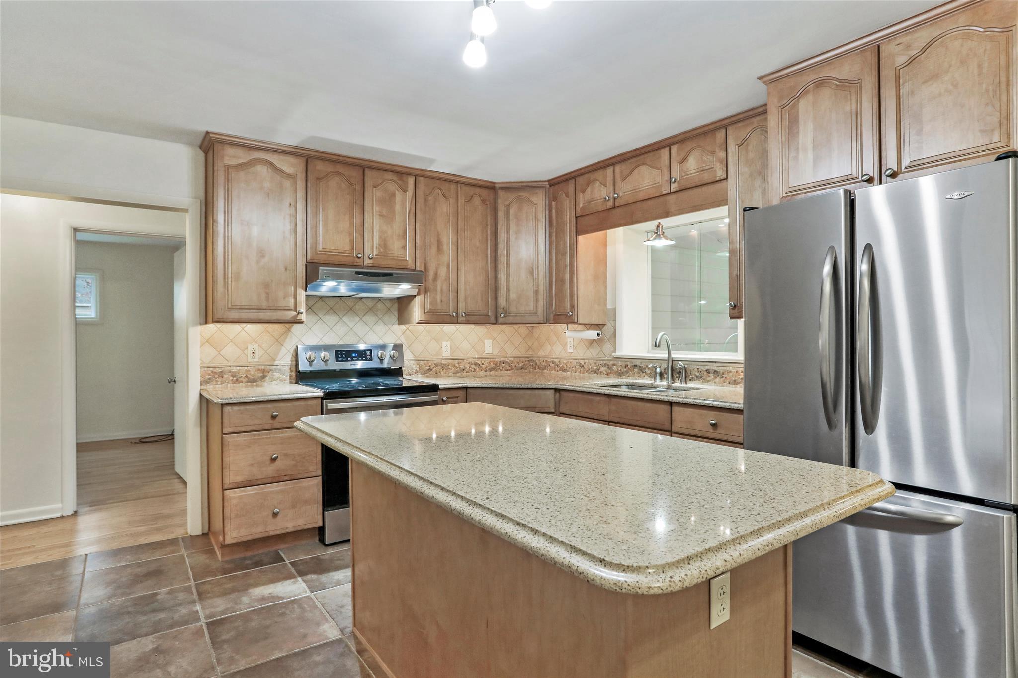 19734 Longmeadow Road Hagerstown, MD 21742 - Photo 12 of 45 a kitchen with kitchen island granite countertop a sink stove and refrigerator