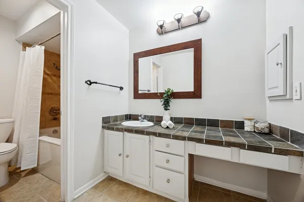 a bathroom with a granite countertop sink and a mirror