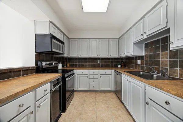 a kitchen with stainless steel appliances granite countertop a sink stove and cabinets