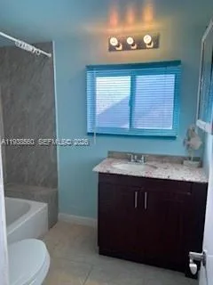 a bathroom with a granite countertop sink a toilet and bathtub