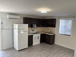 a kitchen with stainless steel appliances granite countertop a refrigerator stove a sink dishwasher and wooden cabinets with wooden floor