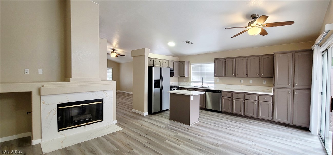 19 Rue De Parc Henderson, NV 89074 - Photo 5 of 23 An open layout connects the kitchen to the living area anchored by a fireplace.