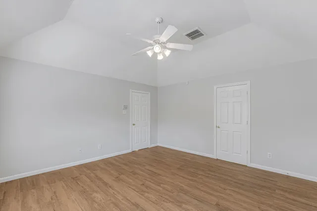 a view of wooden floor and a chandelier fan in a room
