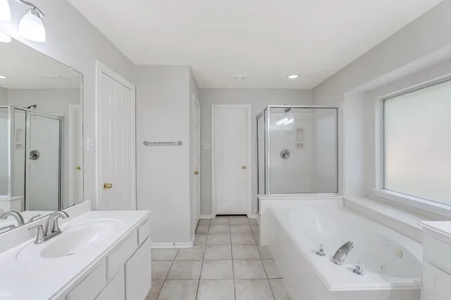 a bathroom with a tub a sink and a mirror