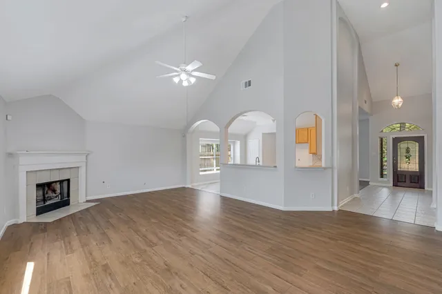 a view of empty room with wooden floor and fireplace