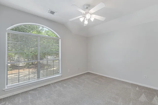 an empty room with a chandelier fan