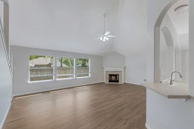 a view of an empty room with a fireplace and a window