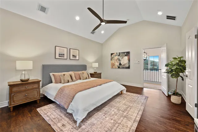 a bedroom with a large bed and a wooden floor