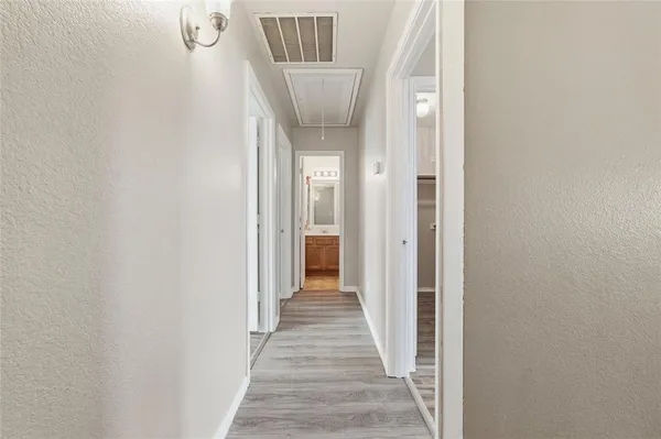 a view of a hallway with wooden floor and entryway