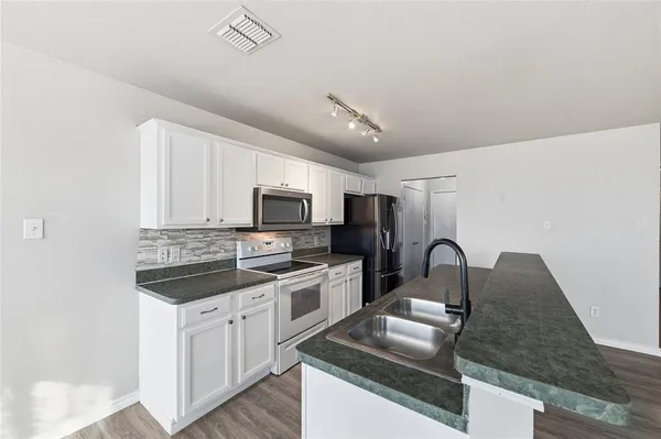 a kitchen with stainless steel appliances granite countertop a sink and stove top oven