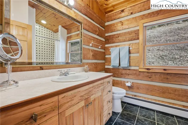 a bathroom with a sink a toilet and a large mirror