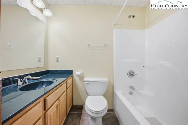 a bathroom with a granite countertop sink a toilet and shower