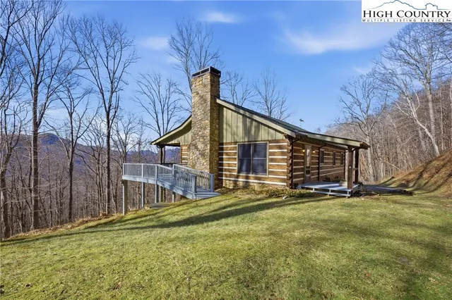a view of an house with backyard and trees