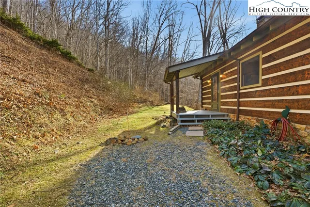a view of a yard with plants and wooden fence