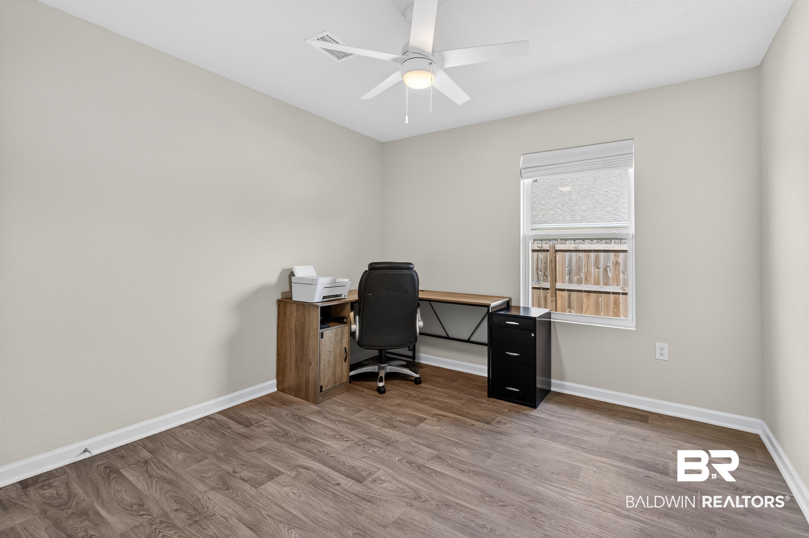 3213 Camino Real Loop Lillian, AL 36549 - Photo 58 of 61 Neutral toned room featuring wood-finish flooring, white baseboards, and a ceiling fan with integrated lighting