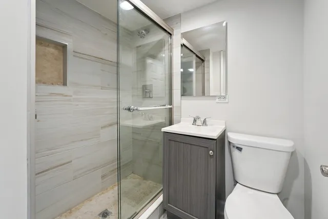a bathroom with a granite countertop sink toilet and shower