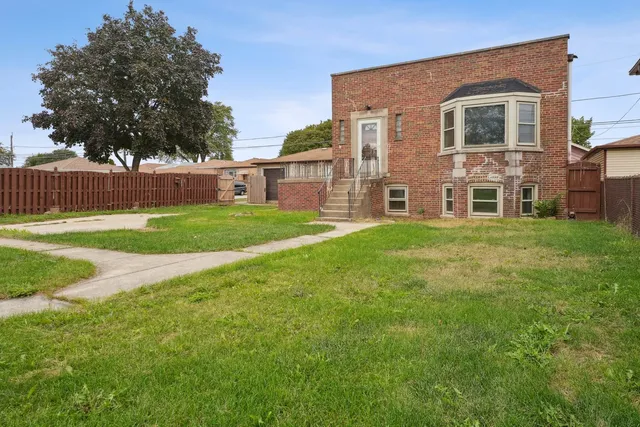 a front view of a house with a yard and trees